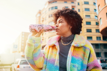 A tourist drinking from a reusable water bottle