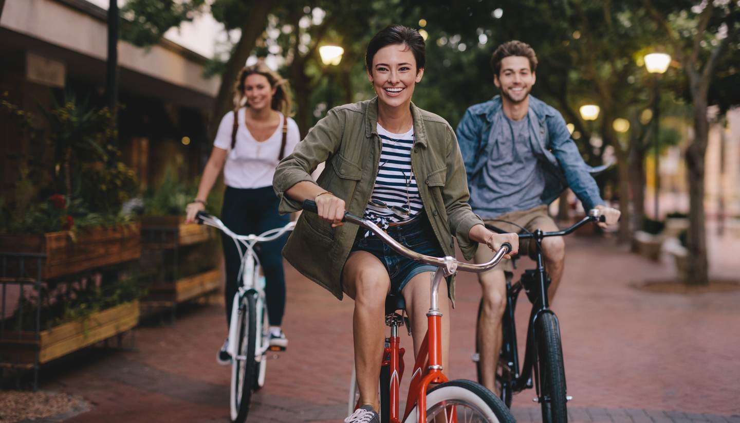 Bike-friendly cities around the world - Three young people cycling down the street
